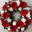 Red roses  and gerberas white carnations funeral wreath sitting on the floor
