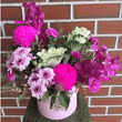 Pink flowers arranged in a pink hatbox