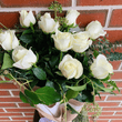 White roses and greenery wrapped in hessian. 